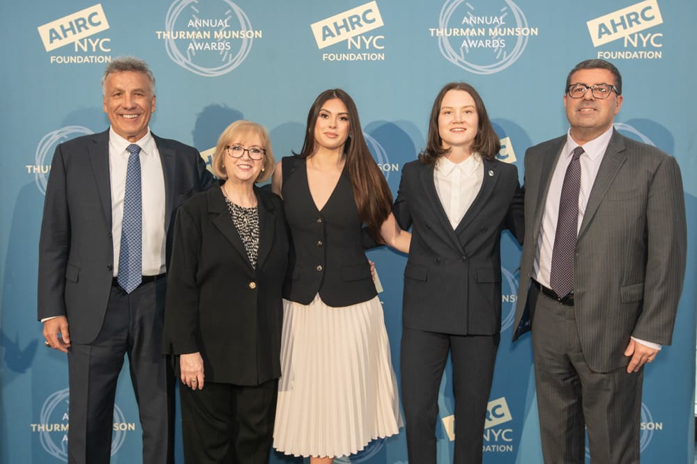 Five people stand in a line against a backdrop printed with the AHRC NYC Foundation and Annual Thurman Munson Awards logos.